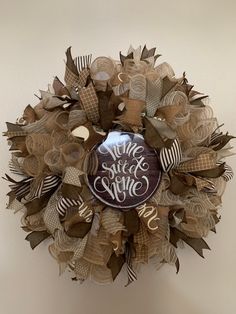 a wreath that has some type of decoration on the front of it with words written on it