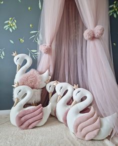 three stuffed animals sitting on top of a bed in front of a canopy with pink drapes