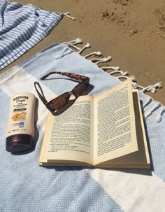 an open book and sunglasses on a blanket