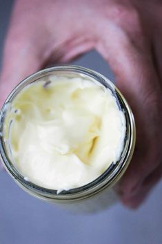 a hand holding a jar filled with whipped cream