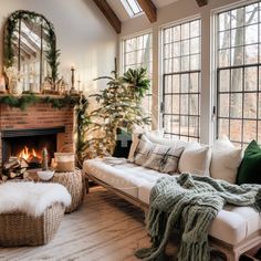 a living room filled with furniture and a fire place in front of a christmas tree