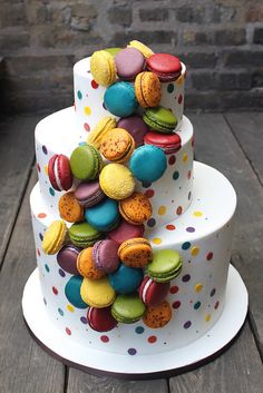 a three tiered cake decorated with colorful macaroons