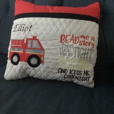 a pillow that has a fire truck on it and reads, read me a story then tuck in tight