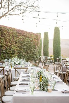 an outdoor dining area with tables and chairs set up for a formal dinner or party