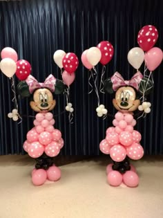 two minnie mouse balloons are standing next to each other