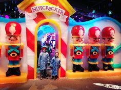 two children are standing in front of a nutcracker display at an amusement park