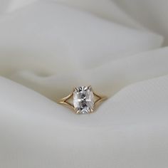 a diamond ring sitting on top of a white cloth