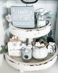 a three tiered shelf with christmas decorations and signs on it's sides in a kitchen