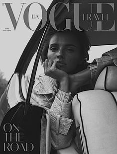 a black and white photo of a woman sitting in a car