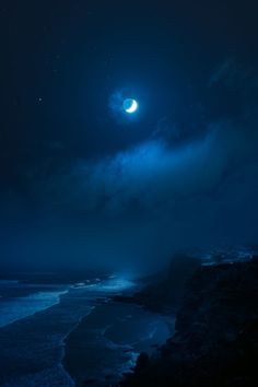 the moon is shining brightly in the night sky over the ocean and rocky shorelines