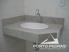 a bathroom sink with a faucet on top of it next to a tiled wall