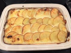 a casserole dish filled with potatoes on top of a stove