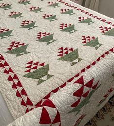 a quilted bed with red and green triangles on it