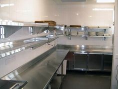 an empty commercial kitchen with stainless steel counters