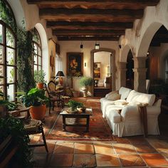 a living room filled with lots of furniture and plants on the floor in front of large windows