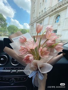 a bouquet of pink flowers sitting in the passenger seat of a car