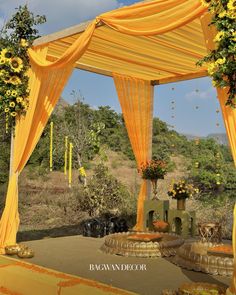 an outdoor wedding setup with yellow drapes and sunflowers on the altar area