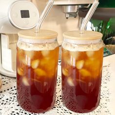 two jars filled with liquid sitting on top of a table