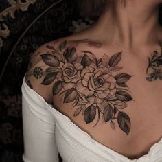 a woman's chest with flowers and leaves tattooed on her upper half - arm