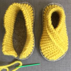 a pair of crocheted slippers next to a pair of scissors