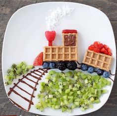 a white plate topped with waffles and fruit