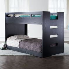 a black bunk bed sitting on top of a wooden floor