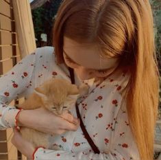 a woman holding a kitten in her arms