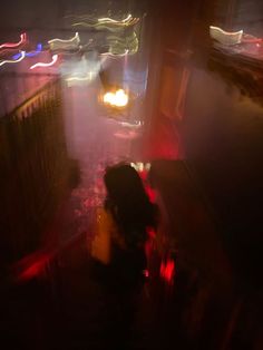 a blurry image of people walking down a street at night