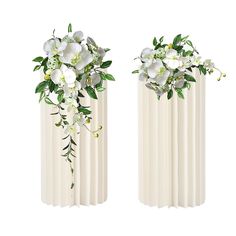 two white vases with flowers and greenery on them