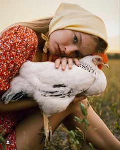 a woman holding a chicken in her arms