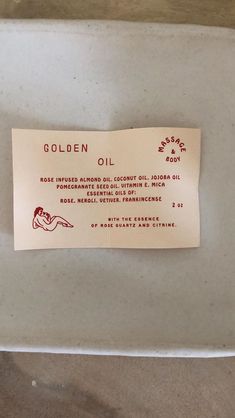 a label on the side of a glass container containing an oil and some other items