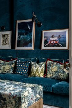 a living room with blue couches and pictures on the wall next to each other