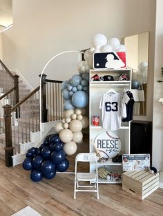 a room filled with balloons and baseball memorabilia on display in front of a staircase case