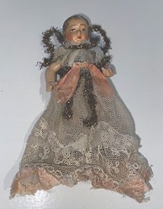 an old doll is sitting on a white surface