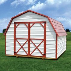 a red and white barn sitting on top of a lush green field