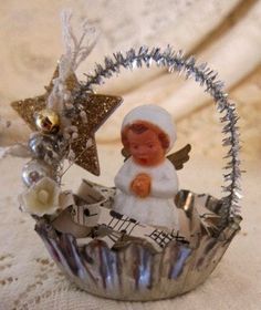 an angel figurine sitting in a cupcake tin