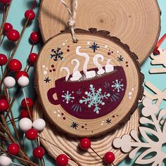 a wooden ornament decorated with snowflakes and coffee cup on it's side