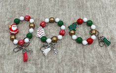 two bracelets with christmas decorations on them sitting on the floor next to each other