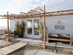 the beach house is decorated with wood and white walls, along with an outdoor seating area