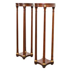 a pair of wooden pedestals with brass accents