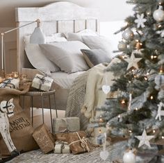 a bedroom decorated for christmas with presents under the tree