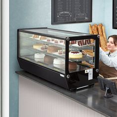 a woman is behind the counter at a bakery