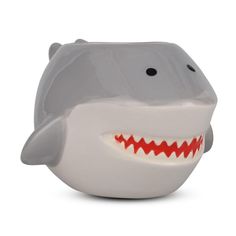 a white shark shaped bowl with red teeth on it's face and mouth open