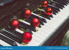 christmas ornaments on an old piano keyboard with red baubles stock photo - image