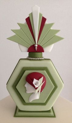 a green and white vase with an image of a woman's head on it