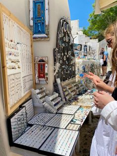 two girls are looking at jewelry on display