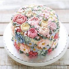 a close up of a cake on a plate with flowers in the middle and frosting