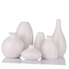 a group of white vases sitting next to each other