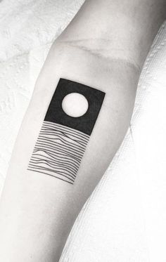 a black and white photo of a person's arm with a tattoo on it