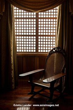 a rocking chair sitting in front of a window